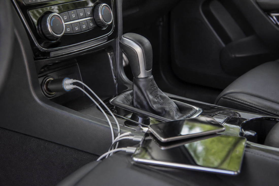 Car charger powering a smartphone and tablet from the vehicle center console