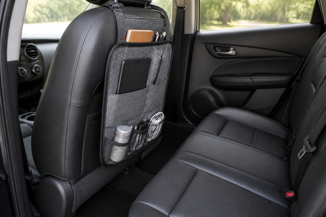 Compact car seat-back organizer installed behind a front seat with clear rear passenger legroom and accessible seatbelts