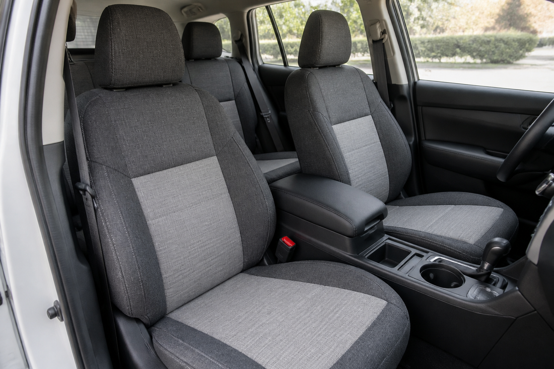 Universal seat covers fitted across a vehicle interior with headrests, seat belts, and seat controls left accessible