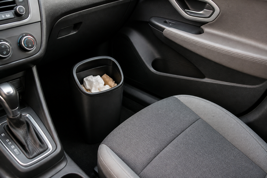 A compact car trash can securely containing wrappers inside an organized vehicle cabin